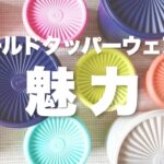放射状の筋が入った特徴的なフタを持つ、カラフルな「オールドタッパーウェア」が複数並べられた写真。オレンジ、ピンク、紫、黄緑、水色、白などの丸型容器が配置されており、中央には白の太文字で「オールドタッパーウェアの魅力」というタイトルテキストが重ねられている。